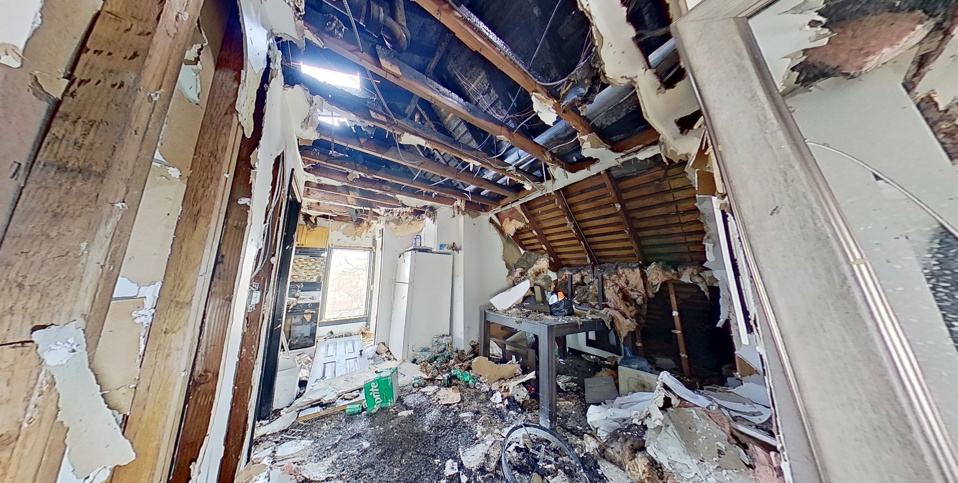 Interior fire damage showing collapsed ceiling and burned contents